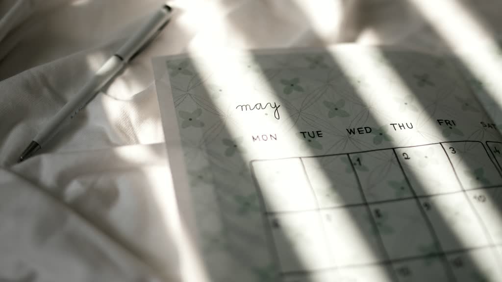 A paper calendar and a pen in morning light