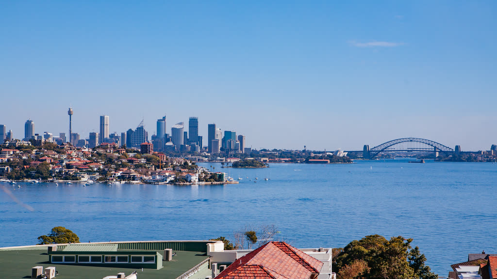 Sydney's city skyline and the Harbour Bridge across the harbour on a clear day