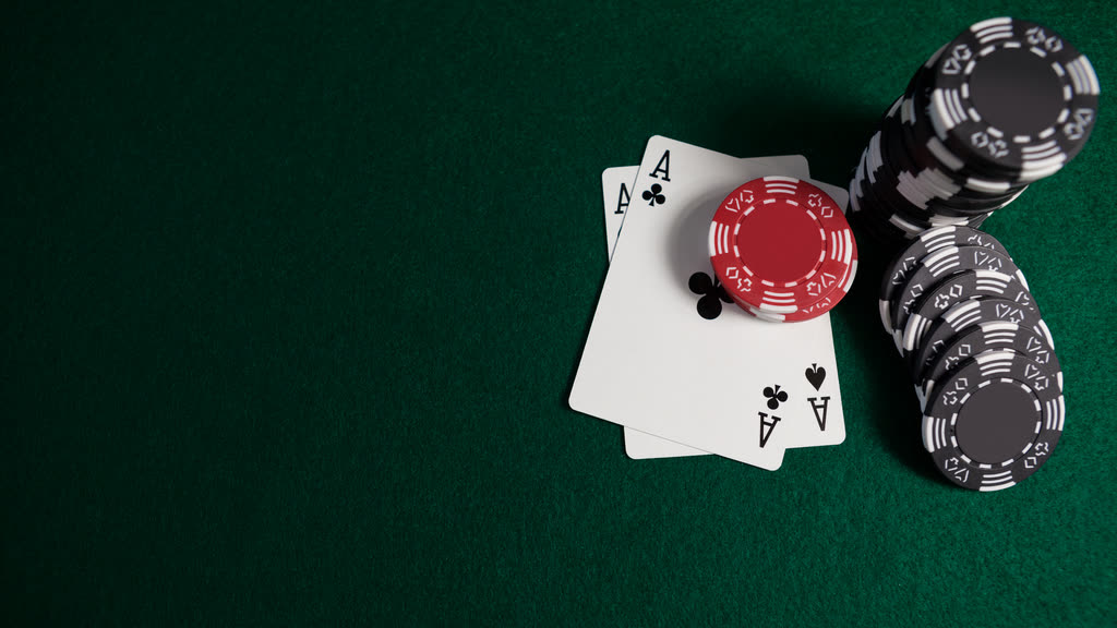 Two aces and stacks of casino chips on green felt