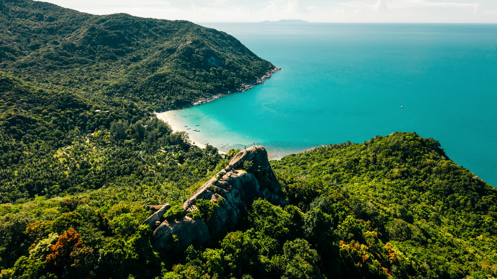 Forested hills and a white-sand bay on Koh Phangan seen from a viewpoint