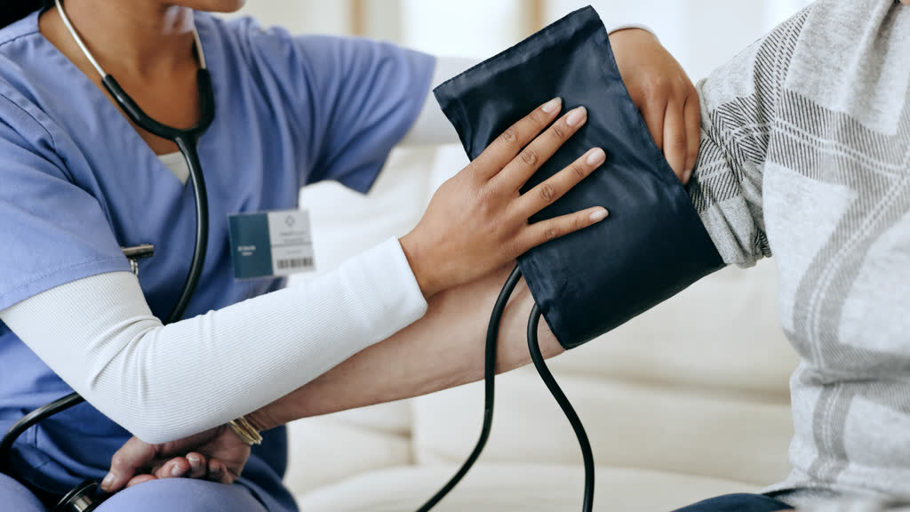 A nurse taking a patient's blood pressure with an arm cuff