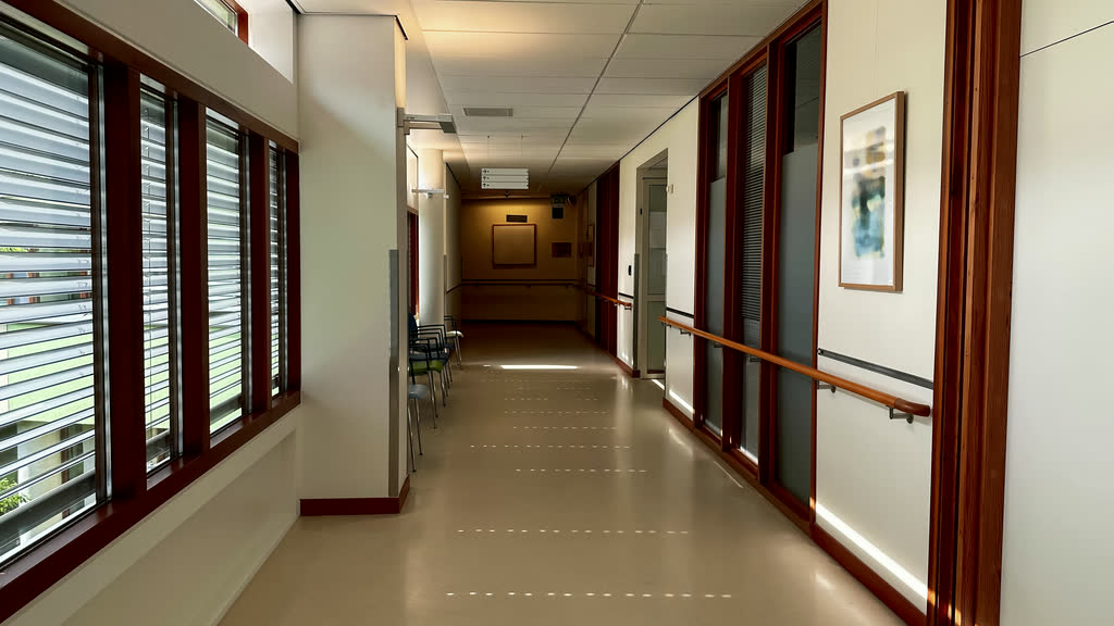 An empty, brightly lit hospital corridor