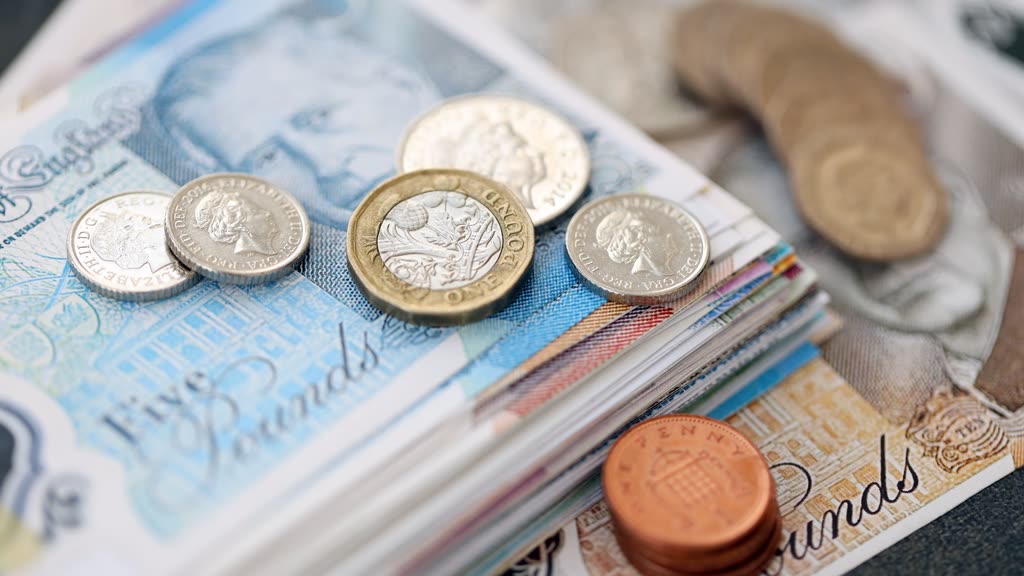 British pound notes and coins on a table
