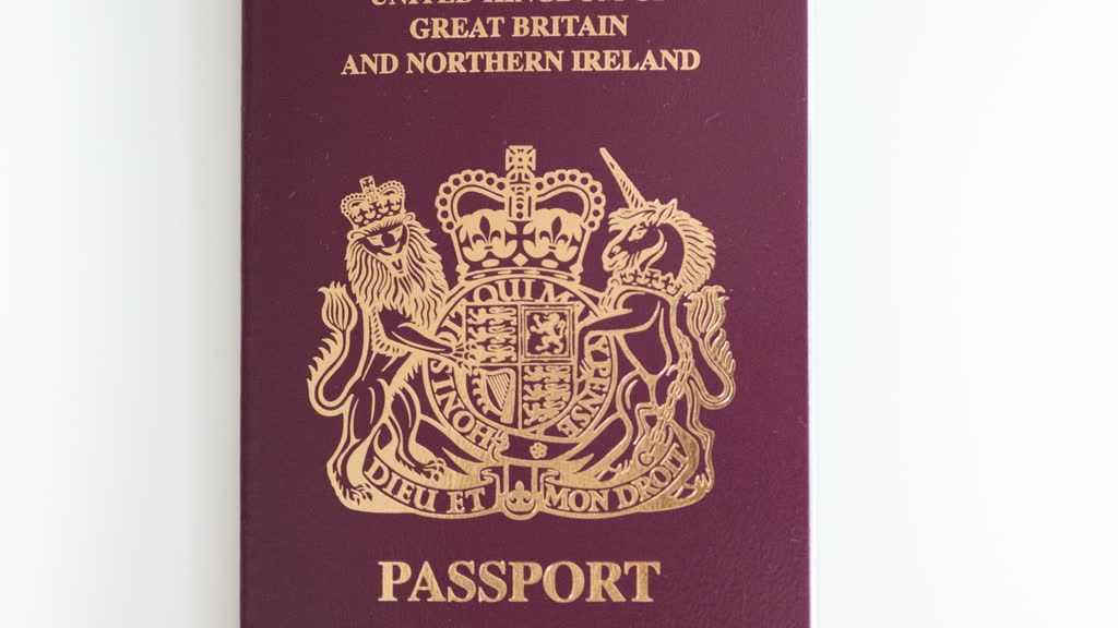 A closed British passport on a white surface